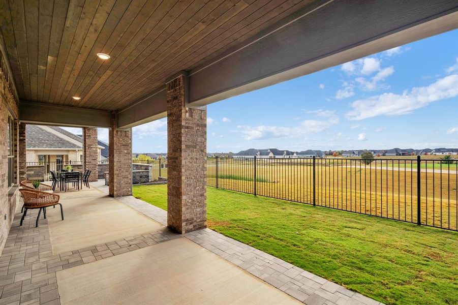 Fenced backyard featuring a patio area, outdoor dining space, and a residential view