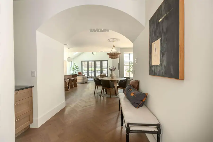 An elegant arched passageway leads into a bright, open-plan living and dining space. An elegant arched passageway leads into a bright, open-plan living and dining space.