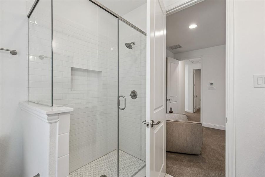 Bathroom with carpet flooring, a shower stall, and recessed lighting