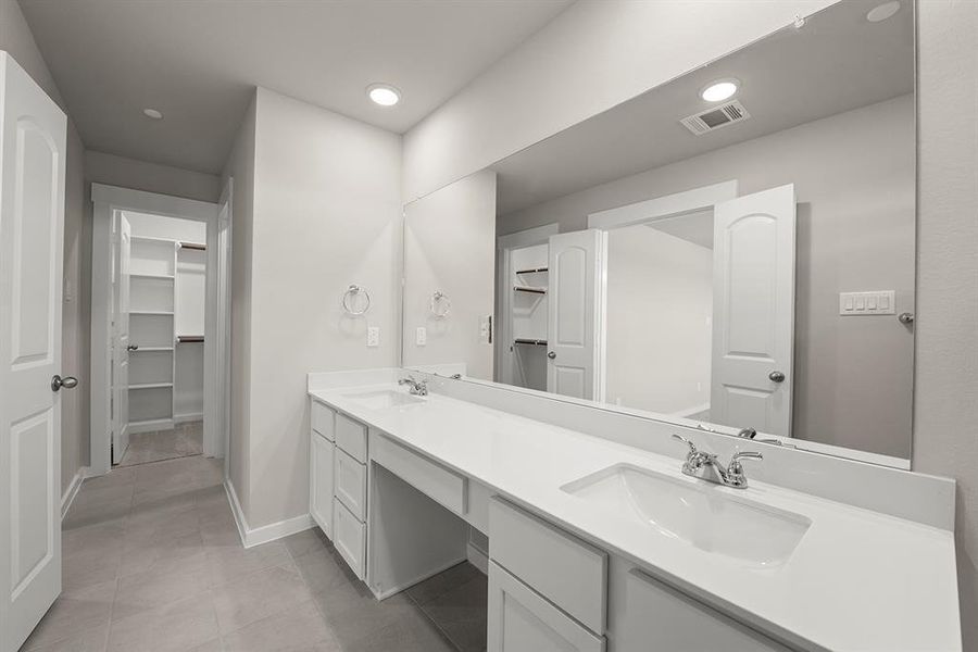 The Primary Bathroom hosts two separate walk in closets.