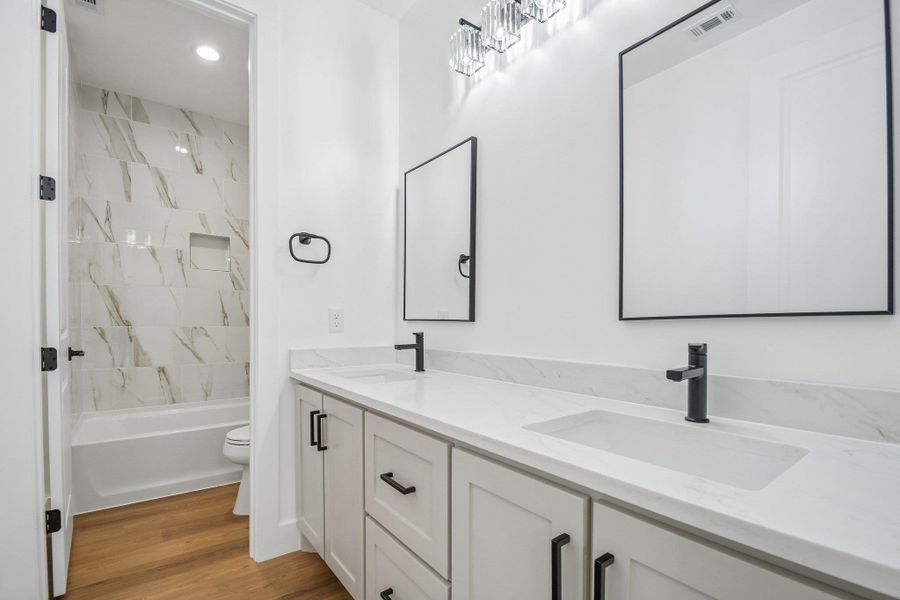 Clean lines and a double vanity define this contemporary primary bath. Clean lines and a double vanity define this contemporary primary bath.
