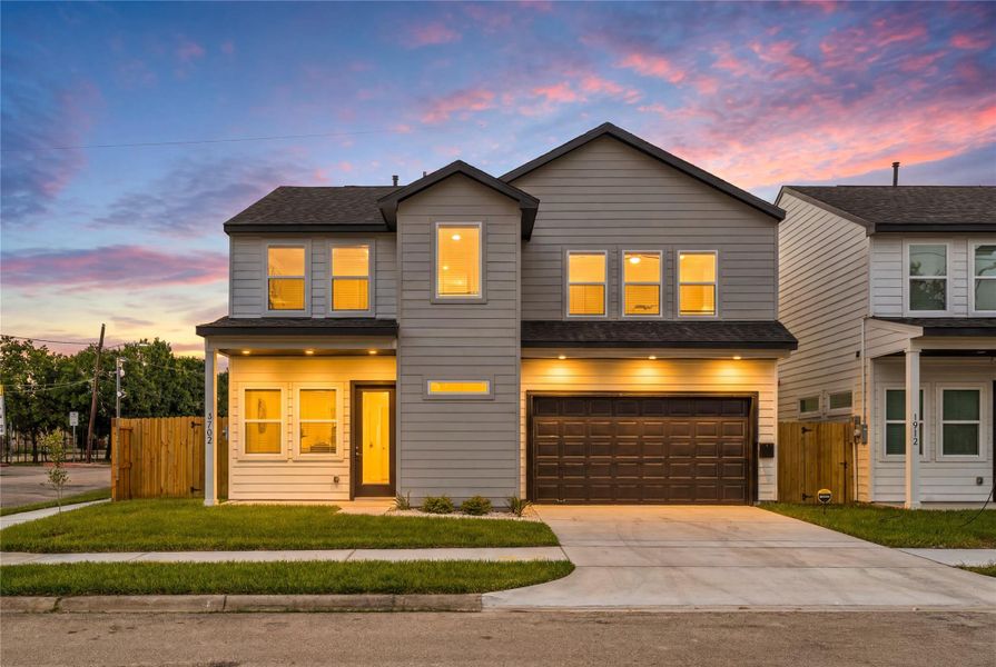 Stunning evening curb appeal — dramatic exterior uplighting beautifully showcases the sharp architectural lines against a vibrant Texas sunset.