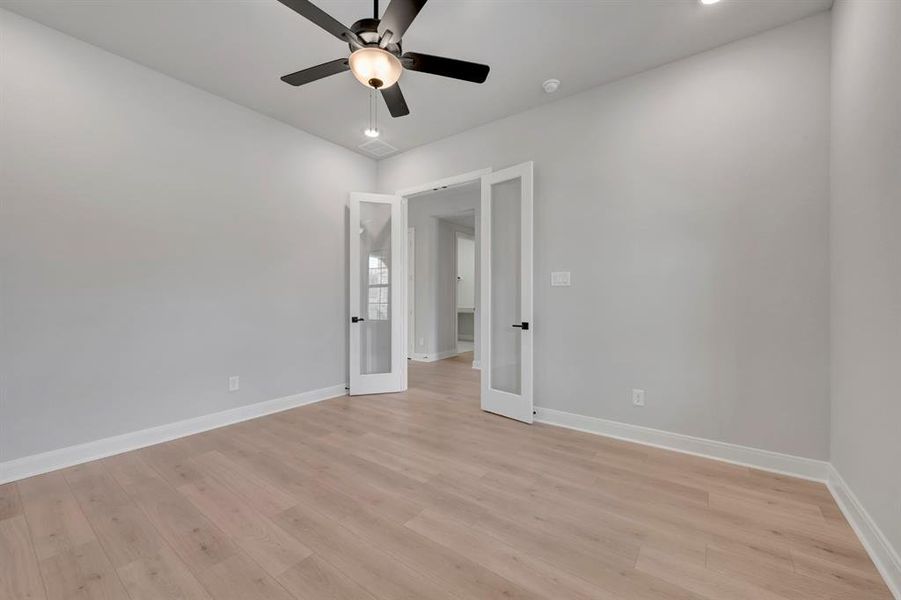 Unfurnished bedroom with ceiling fan, light wood finished floors, recessed lighting, and french doors