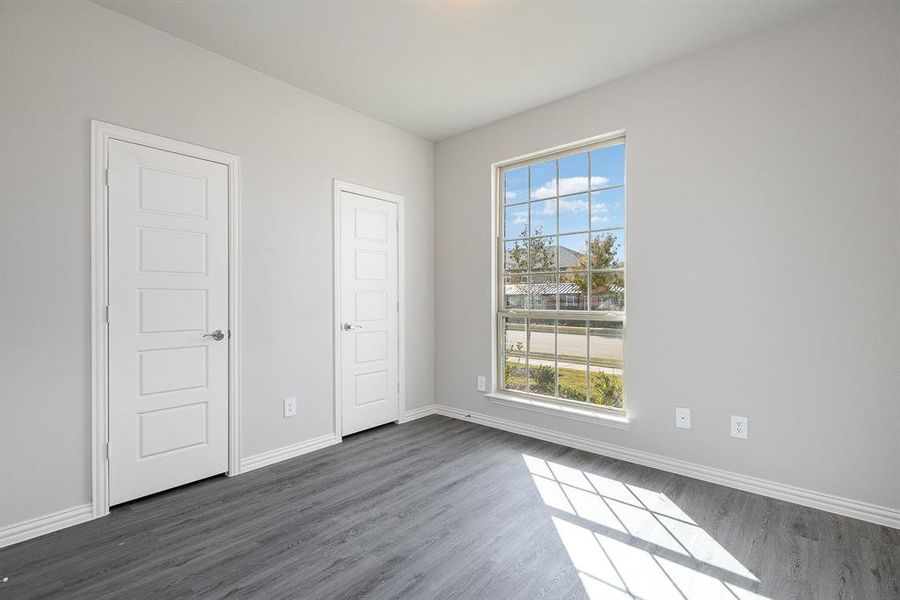 Unfurnished bedroom with dark hardwood / wood-style floors