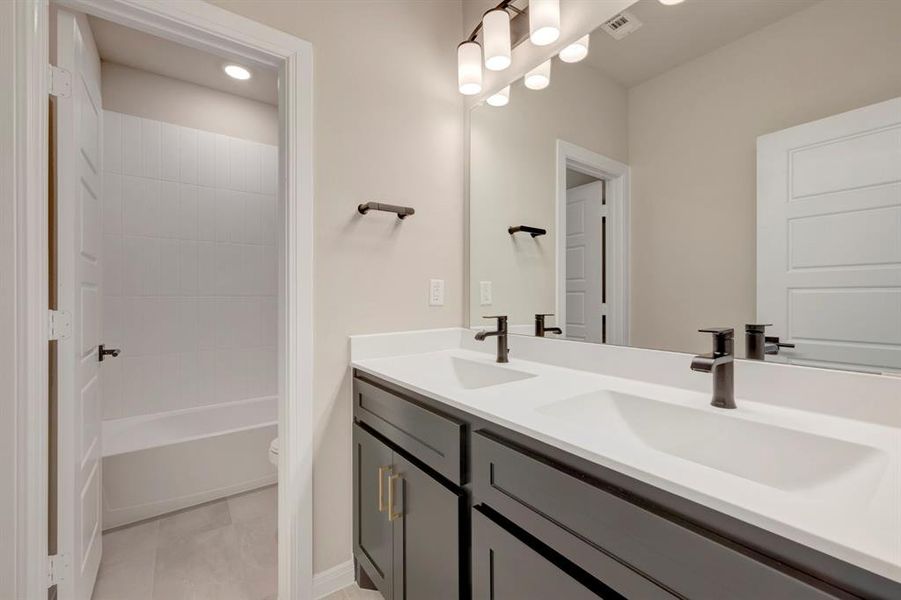 Full bath with double vanity, bathtub / shower combination, and recessed lighting
