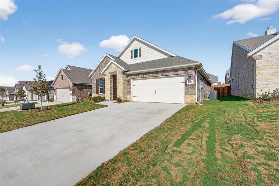 Craftsman inspired home with concrete driveway, roof with shingles, and brick siding