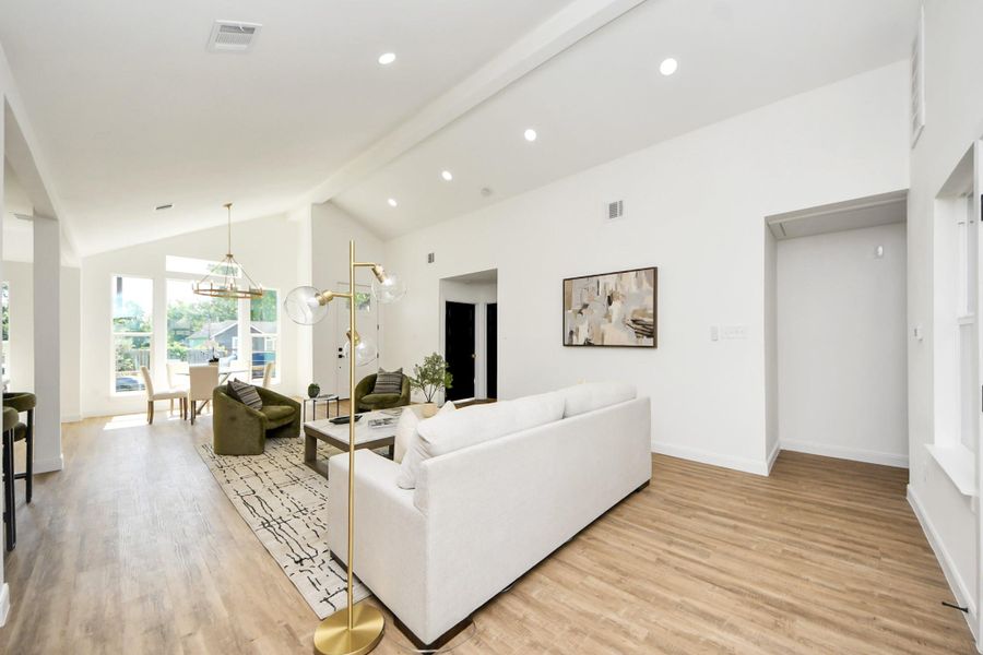 An open, light-filled space where high ceilings and modern lighting create a sense of ease and elegance. Thoughtfully furnished with cozy seating and a dining area that feels both stylish and relaxed—perfect for everyday living or effortless entertaining.