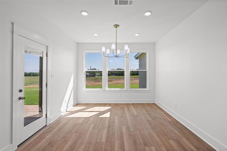 Interior space featuring wood-finish flooring, white walls, and recessed lighting