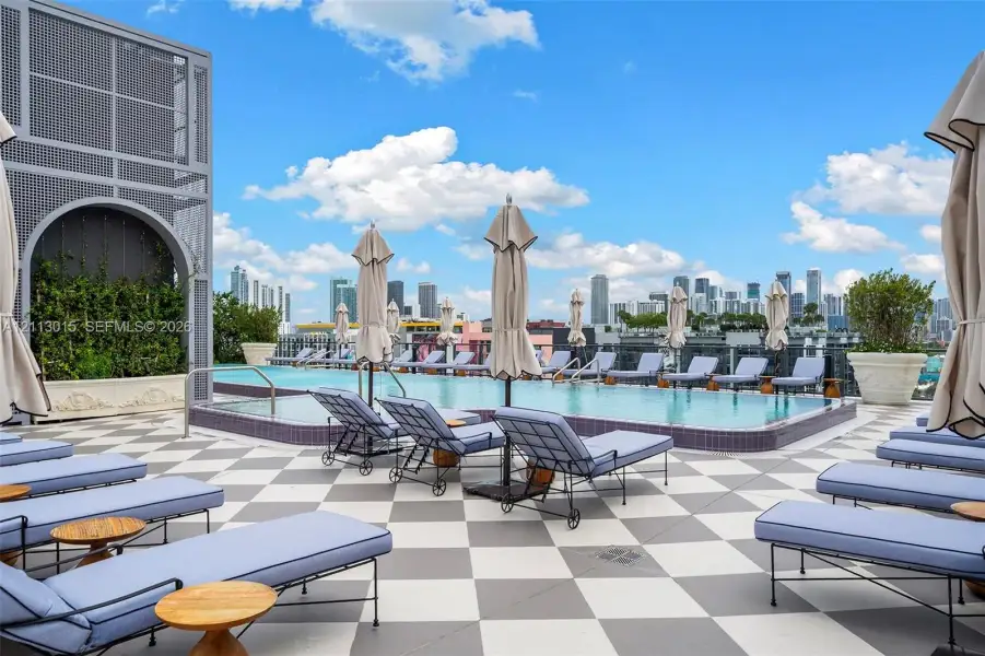 Rooftop infinity-edge pool featuring a geometric tiled deck and large-scale architectural planters