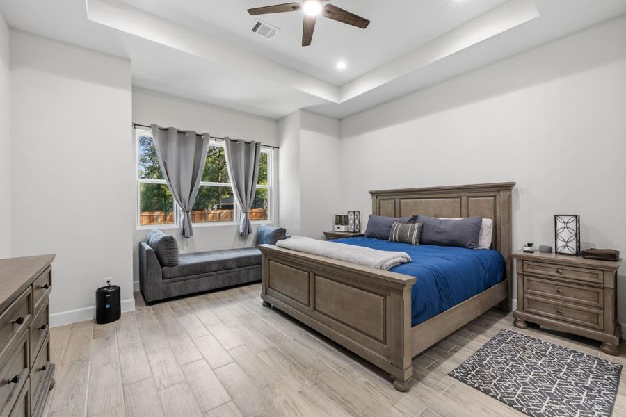 PRIMARY BEDROOM -Spacious primary retreat features a tray ceiling, abundant natural light.