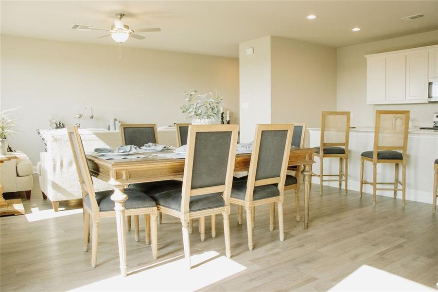 Dining area with light hardwood / wood-style flooring and ceiling fan