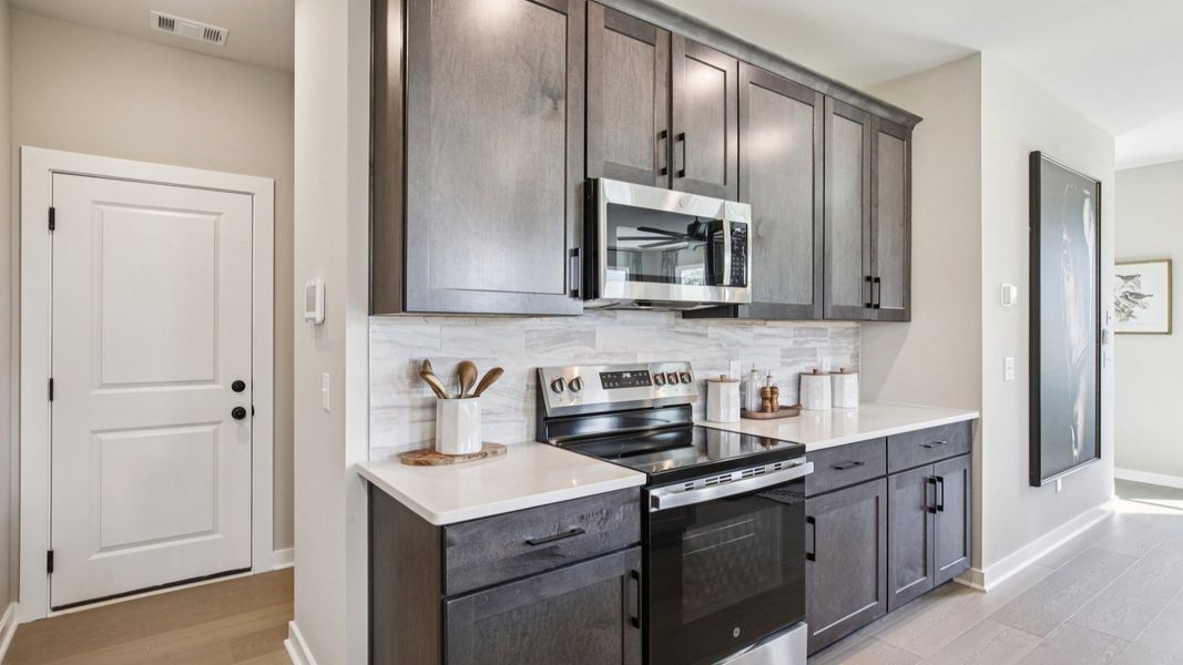 Kitchen with quartz countertops and dark cabinetry