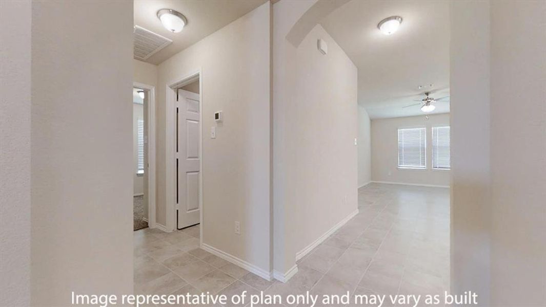 Hallway with arched walkways, healthy amount of natural light, and light tile patterned floors Hallway with arched walkways, healthy amount of natural light, and light tile patterned floors