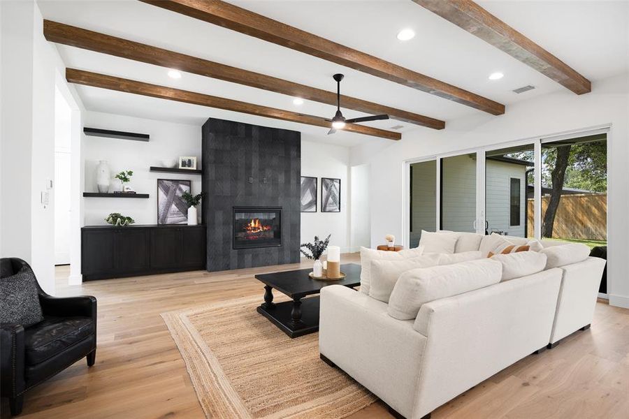 Living room with a fireplace, recessed lighting, light wood-style floors, a ceiling fan, and beam ceiling Living room with a fireplace, recessed lighting, light wood-style floors, a ceiling fan, and beam ceiling