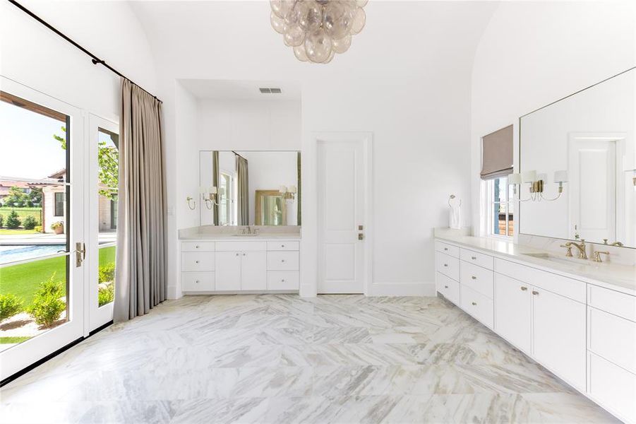 Primary bath features dual closets, access to the backyard, and a makeup vanity area.