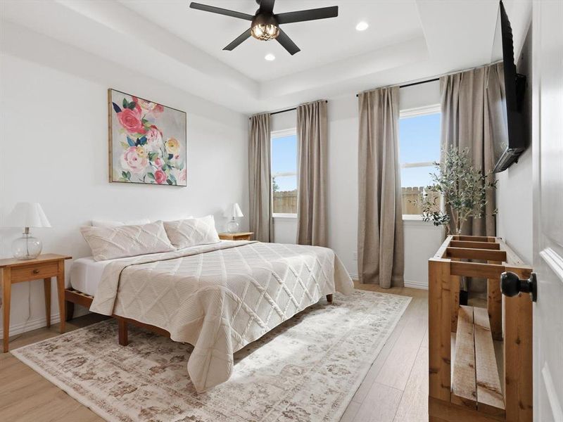 Primary bedroom is a relaxing oasis with large windows and coffered ceilings.