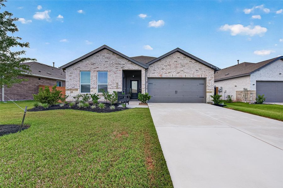 Front exterior featuring brick construction, an attached two-car garage, and well-maintained landscaping. Front exterior featuring brick construction, an attached two-car garage, and well-maintained landscaping.