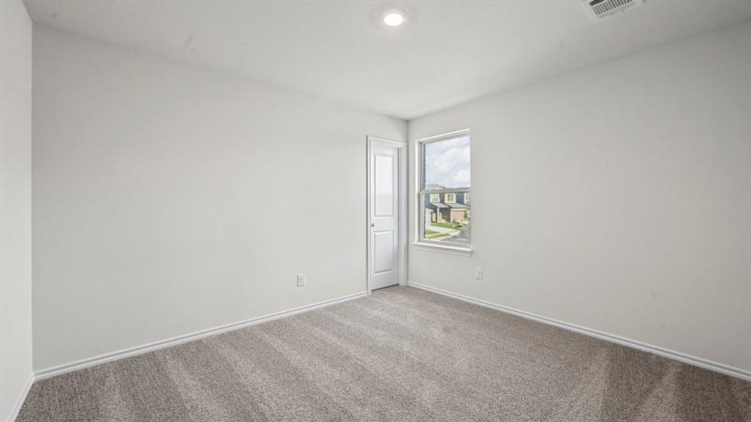 Neutral-toned room featuring light gray carpeting, white painted walls, a single window, and a white interior door