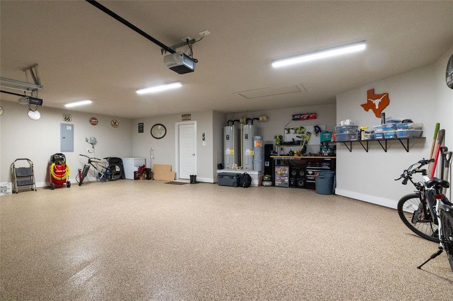Garage with electric panel, water heater, and a garage door opener