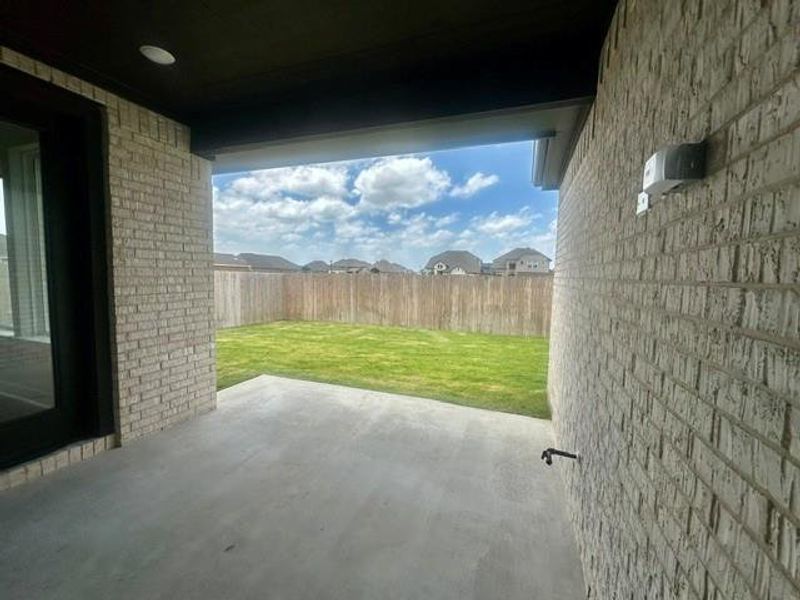 A spacious covered patio opens to a fully fenced yard, offering privacy and outdoor leisure. A spacious covered patio opens to a fully fenced yard, offering privacy and outdoor leisure.