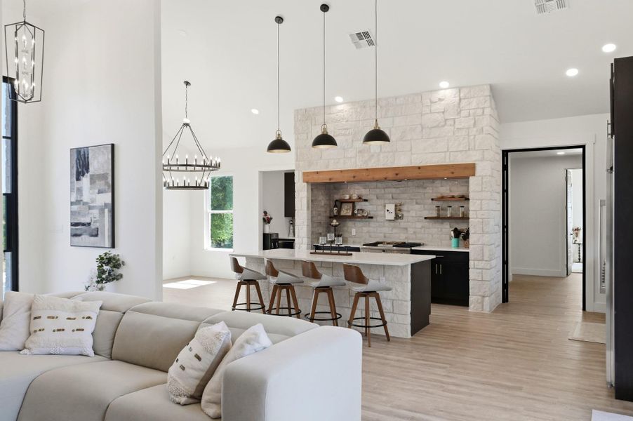 Gleaming wood floors flow seamlessly beneath soaring ceilings and an elegant stone archway.