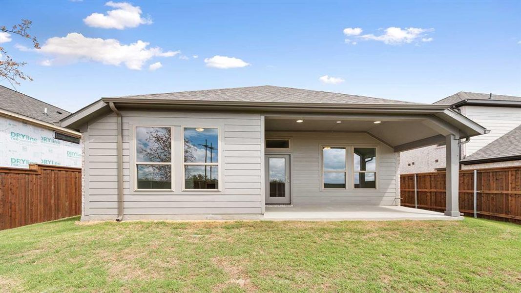 Back of property with a lawn and a patio area