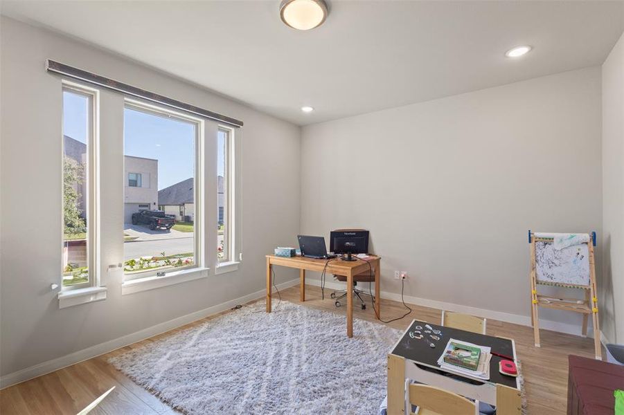 Office space with light wood-type flooring and recessed lighting Office space with light wood-type flooring and recessed lighting