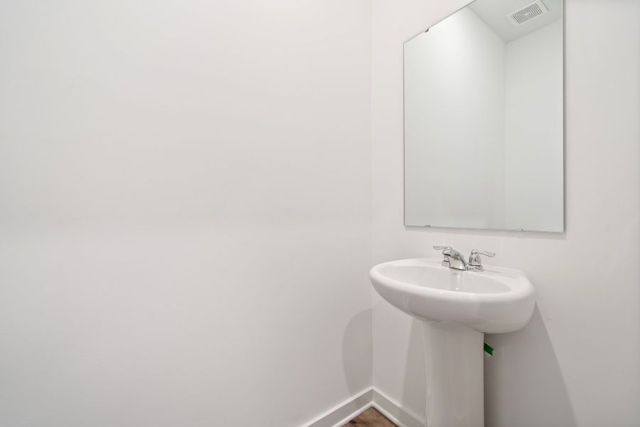 A bathroom with a mirror and sink. A bathroom with a mirror and sink.