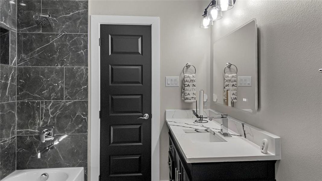 Bathroom featuring vanity, shower / bathtub combination, and a textured wall