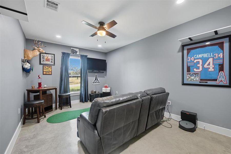 Home theater featuring ceiling fan, recessed lighting, and finished concrete floors Home theater featuring ceiling fan, recessed lighting, and finished concrete floors