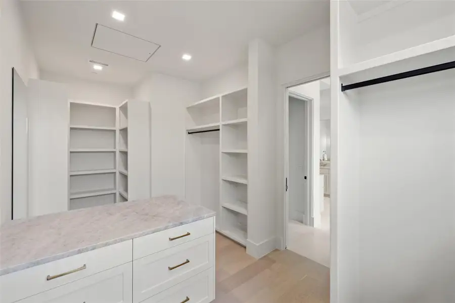 Spacious closet featuring light wood-style floors Spacious closet featuring light wood-style floors