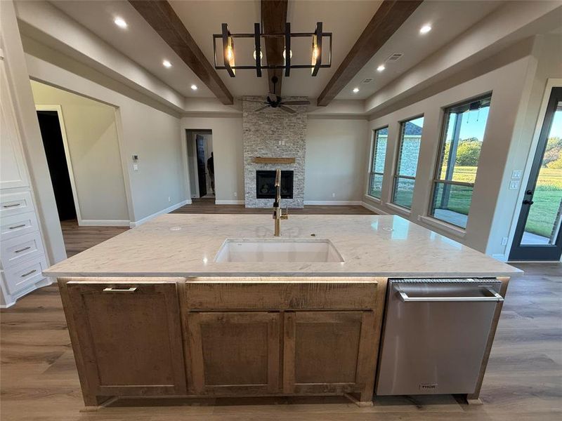 Kitchen with beam ceiling, dark wood-style floors, dishwasher, a kitchen island with sink, and open floor plan Kitchen with beam ceiling, dark wood-style floors, dishwasher, a kitchen island with sink, and open floor plan