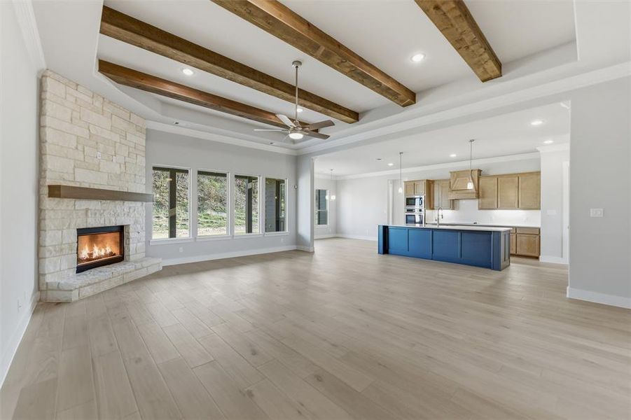 Unfurnished living room featuring recessed lighting, a fireplace, a ceiling fan, crown molding, and beam ceiling