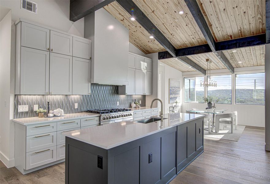 Kitchen featuring a sink, tasteful backsplash, light countertops, light wood-style flooring, and wood ceiling Kitchen featuring a sink, tasteful backsplash, light countertops, light wood-style flooring, and wood ceiling