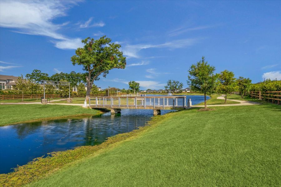 Charming pedestrian bridge connects winding trails around the lake, creating an easy loop for morning walks or evening strolls. Open green space, mature trees, and water views come together for a peaceful, thoughtfully designed setting. Charming pedestrian bridge connects winding trails around the lake, creating an easy loop for morning walks or evening strolls. Open green space, mature trees, and water views come together for a peaceful, thoughtfully designed setting.