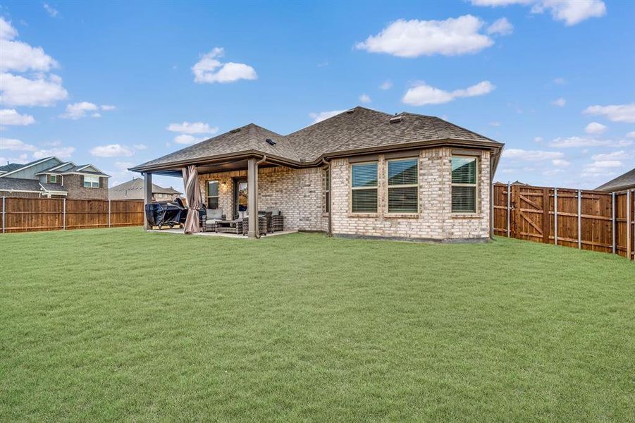 Back of house with a yard and a patio area