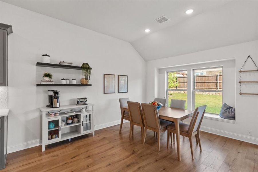 Dining space with light wood-style floors, recessed lighting, and vaulted ceiling
