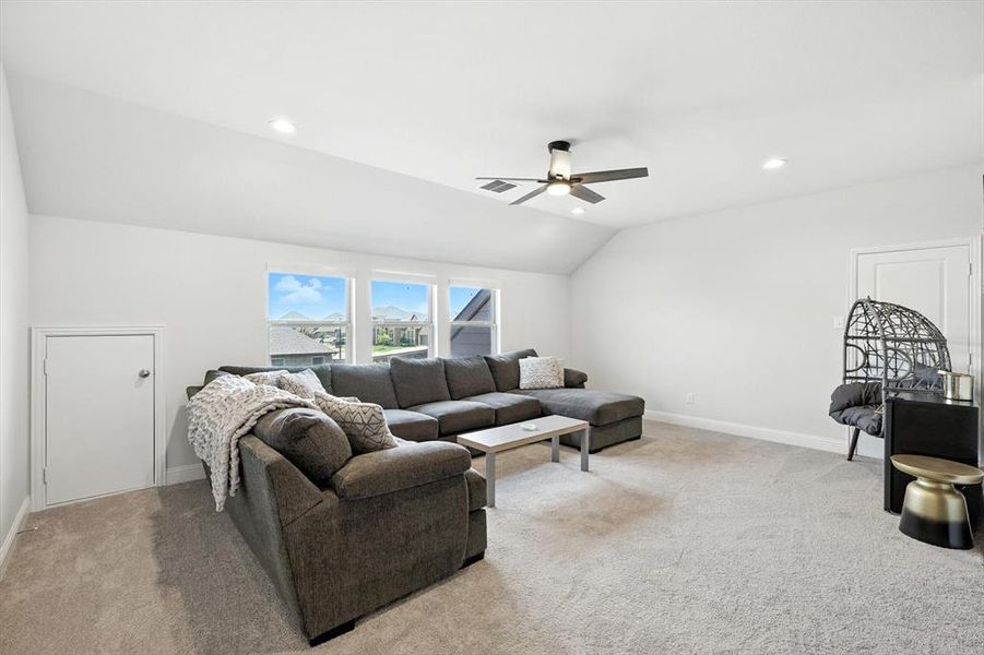 Living room featuring recessed lighting, a ceiling fan, vaulted ceiling, and carpet