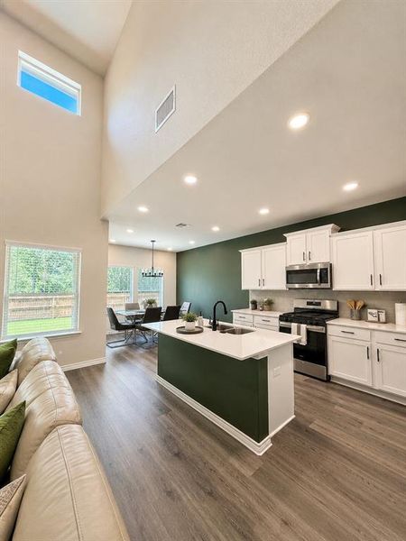 Open-concept living space featuring high ceilings and wood-finish flooring