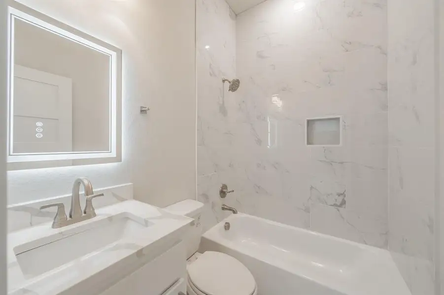 Full bath with shower / washtub combination, vanity, and a textured wall