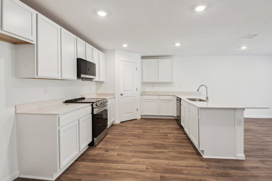 A kitchen with white cabinets.