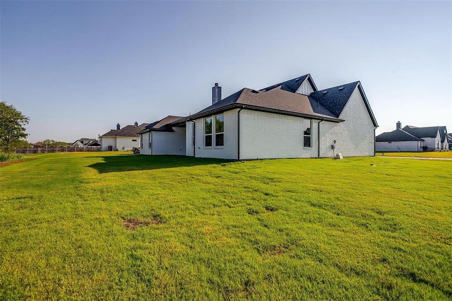 View of property exterior featuring a lawn