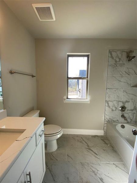 Ensuite bath 3 in bed 4 with Monet Quartz vanity, White Shaker cabinets, oversized 12x24 marble-style tiled shower/bath, and window for natural light.