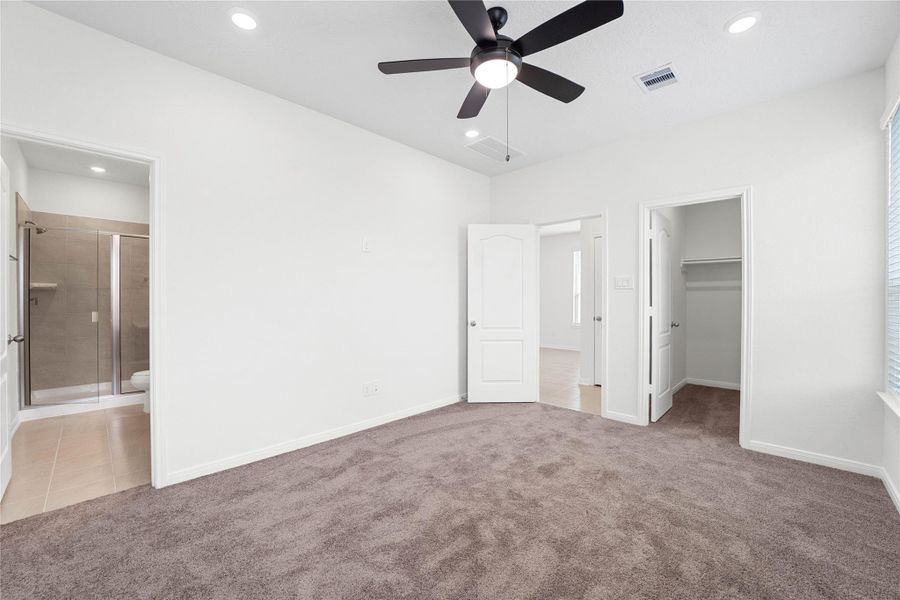 Additional view of the primary bedroom with views of the walk-in closet and ensuite bathroom. Additional view of the primary bedroom with views of the walk-in closet and ensuite bathroom.