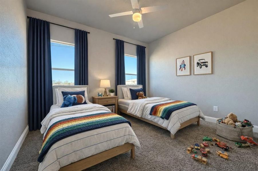 Carpeted bedroom with a ceiling fan and baseboards