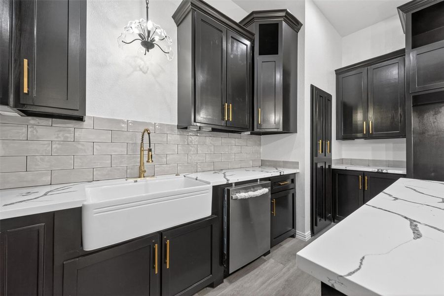 Stunning chef’s kitchen with oversized island, abundant custom cabinetry, modern finishes, and ample prep space for everyday living.