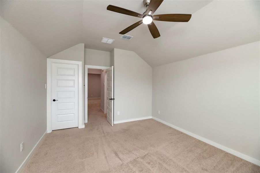 Additional living space featuring lofted ceiling, light carpet, and ceiling fan Additional living space featuring lofted ceiling, light carpet, and ceiling fan