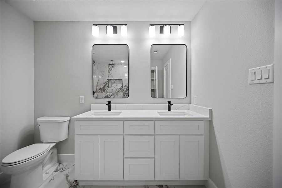 Full bath featuring a sink, baseboards, toilet, and marble finish floor