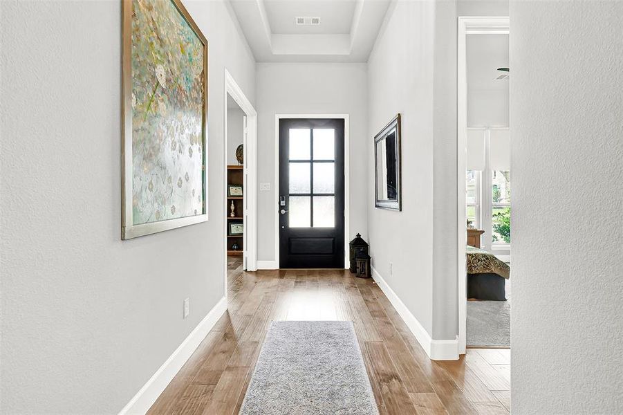 Foyer entrance featuring light wood-type flooring and a textured wall