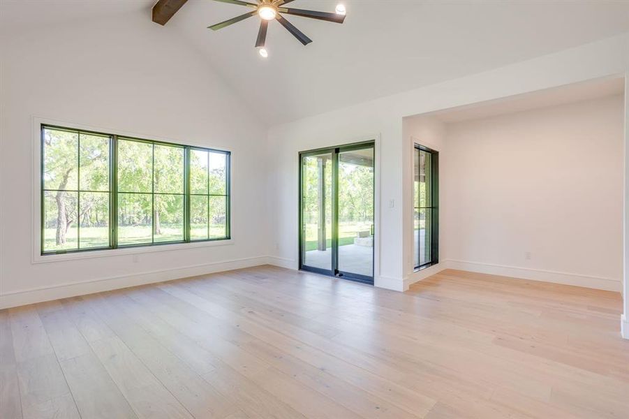Empty room with a ceiling fan and light wood finished floors
